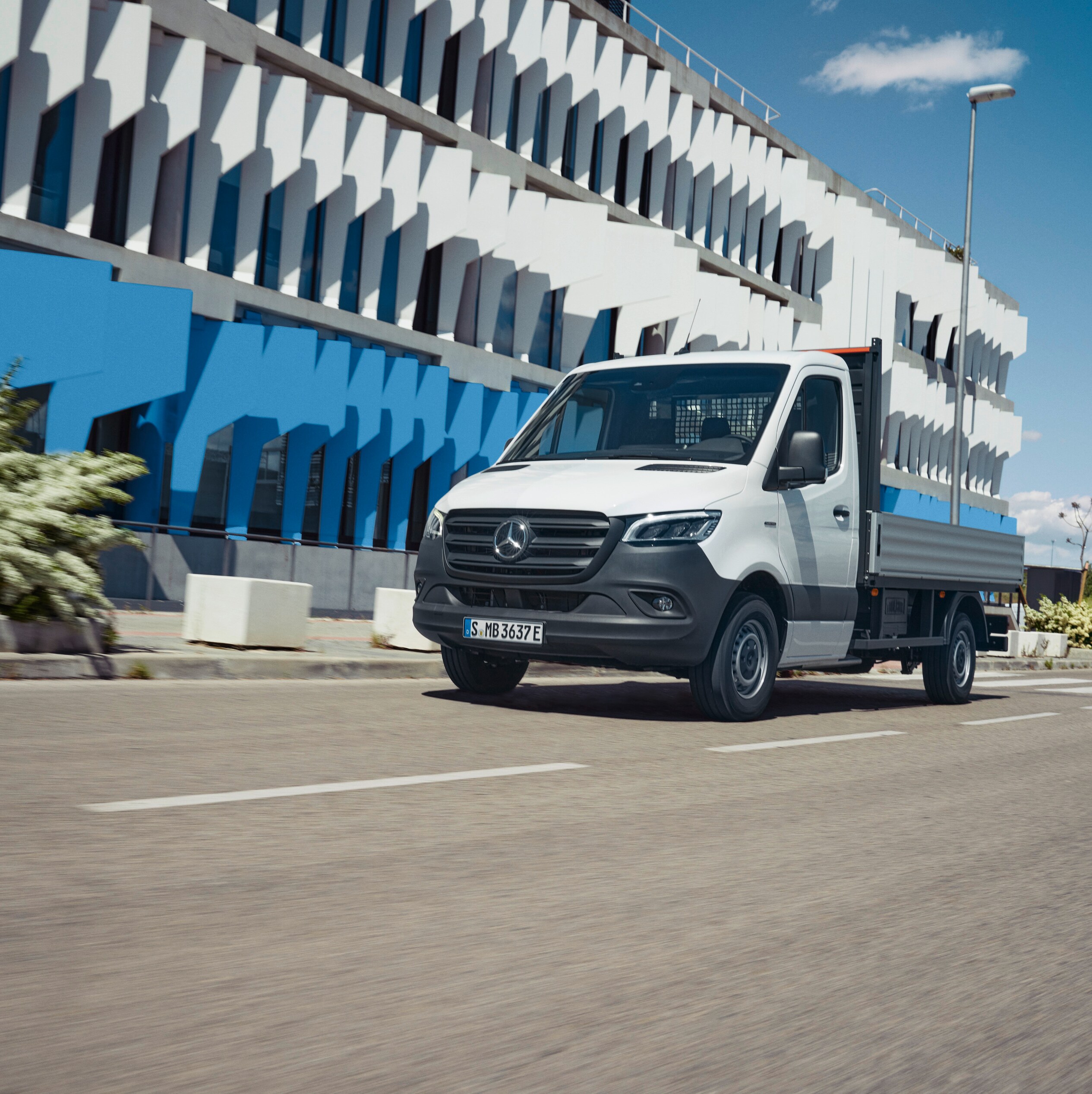 Le Mercedes-Benz eSprinter à plateau en déplacement en ville.