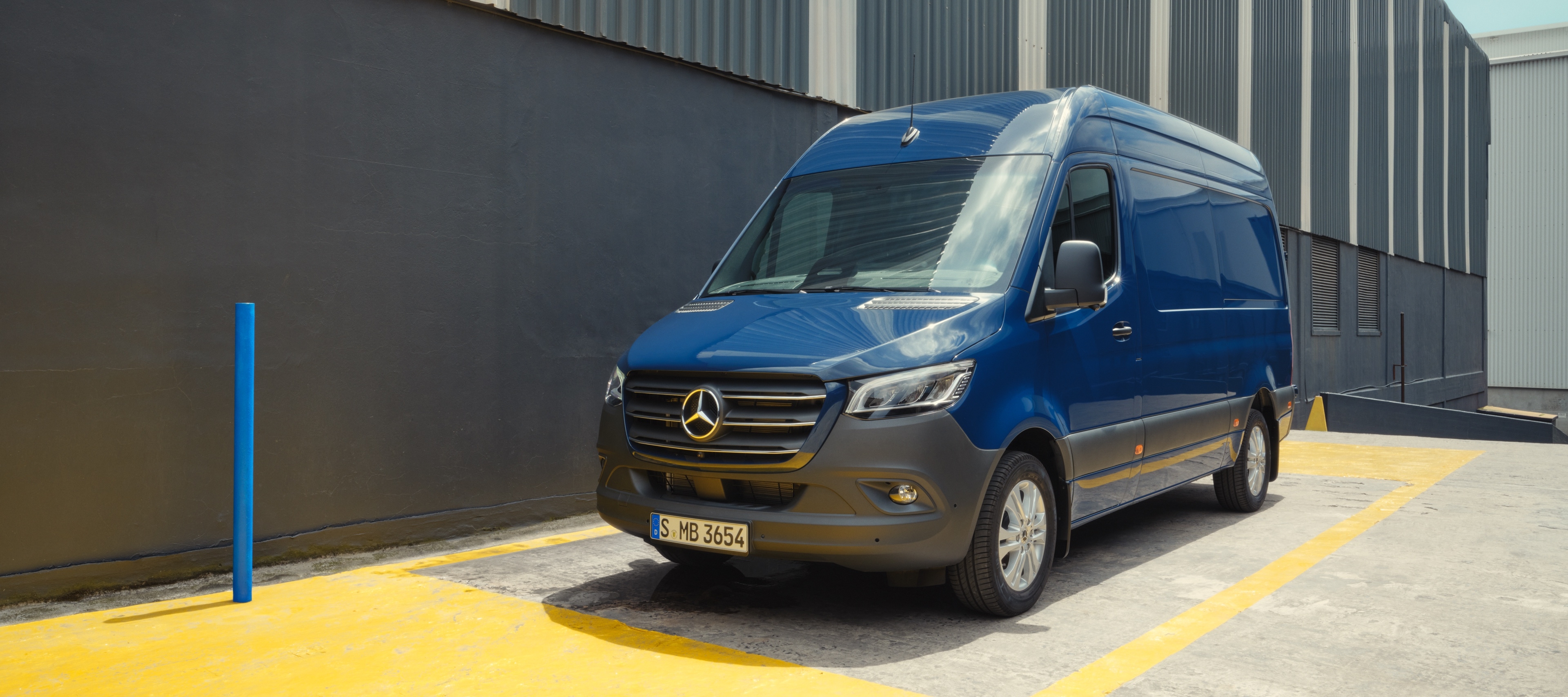 Gerbrauchte Sprinter von Mercedes-Benz Mercedes-Benz Sprinter bleu stationné sur une place de parking devant un bâtiment industriel.