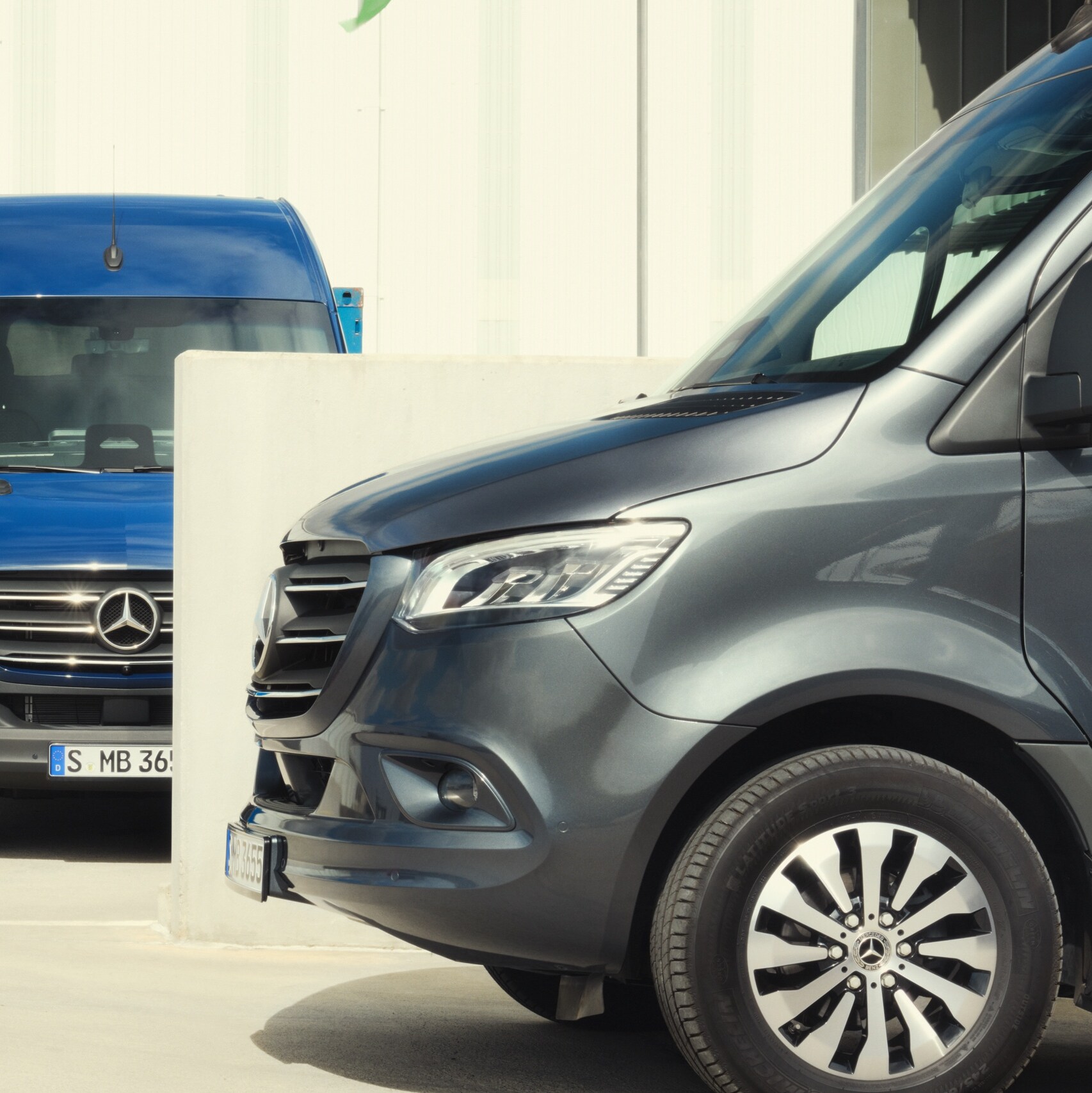 L’utilitaire Mercedes-Benz SprinterMercedes-Benz Sprinter fourgon stationné sur un parking à côté d'un conteneur. fourgon est stationné ouvert sur un parking à côté de caisses prêtes à être chargées. 