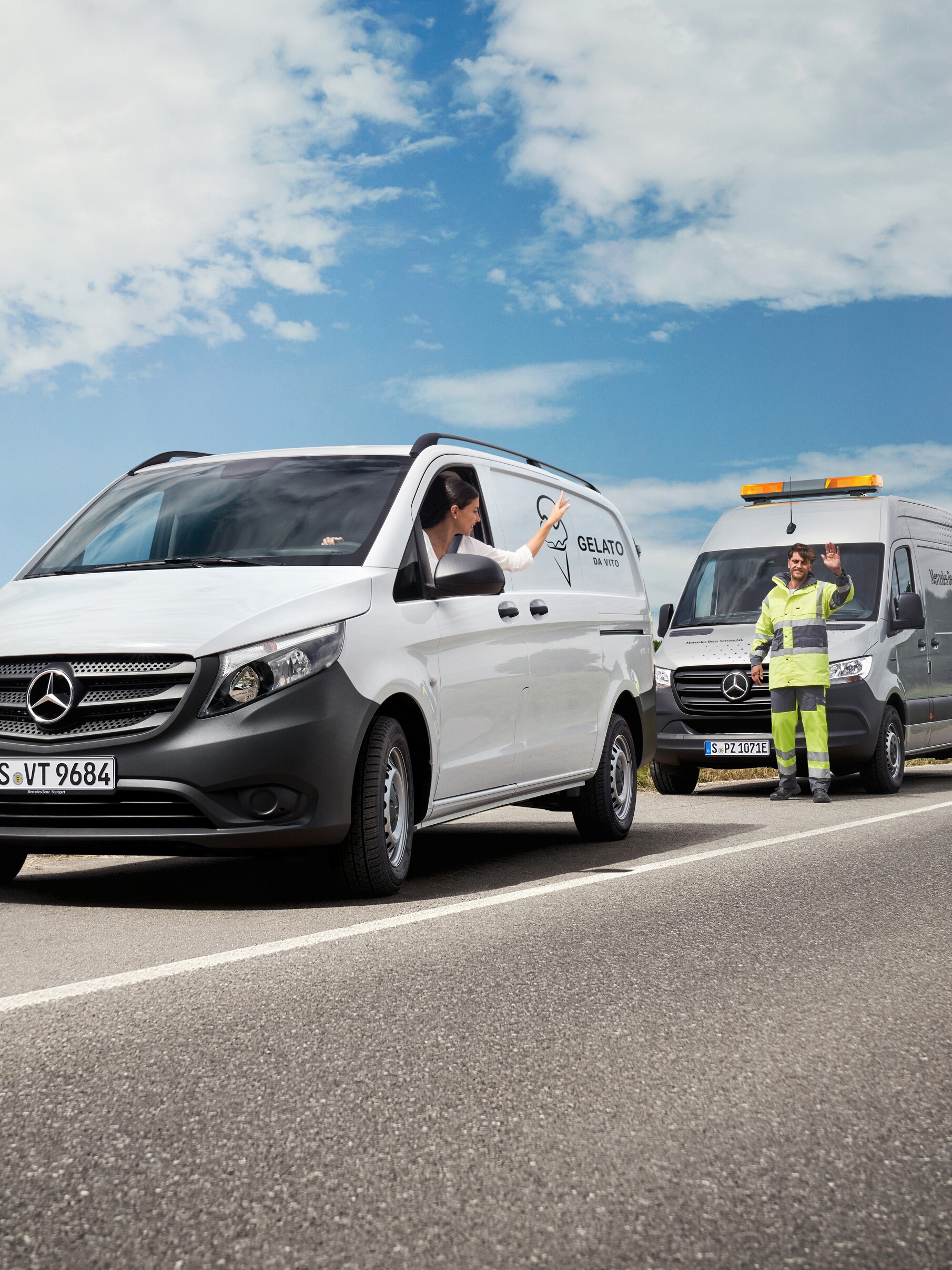 Une femme assise dans une Mercedes-Benz Vito blanche salue un technicien de maintenance Mercedes-Benz sur le bord de la route.