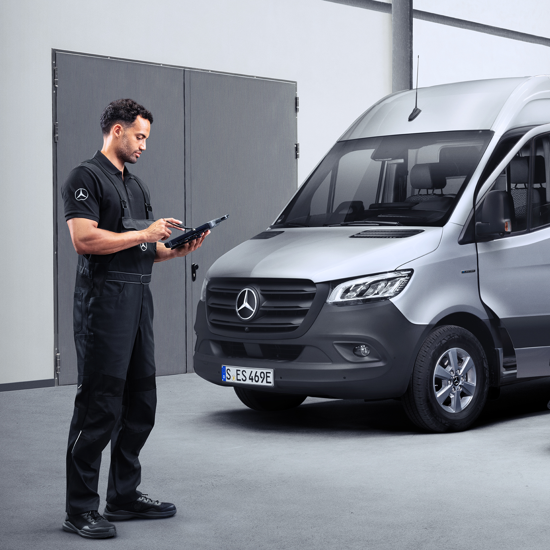 Partenaire de service Mercedes-Benz | Maintenance et inspection Un partenaire de service Mercedes-Benz consulte une tablette devant une Mercedes-Benz eSprinter.