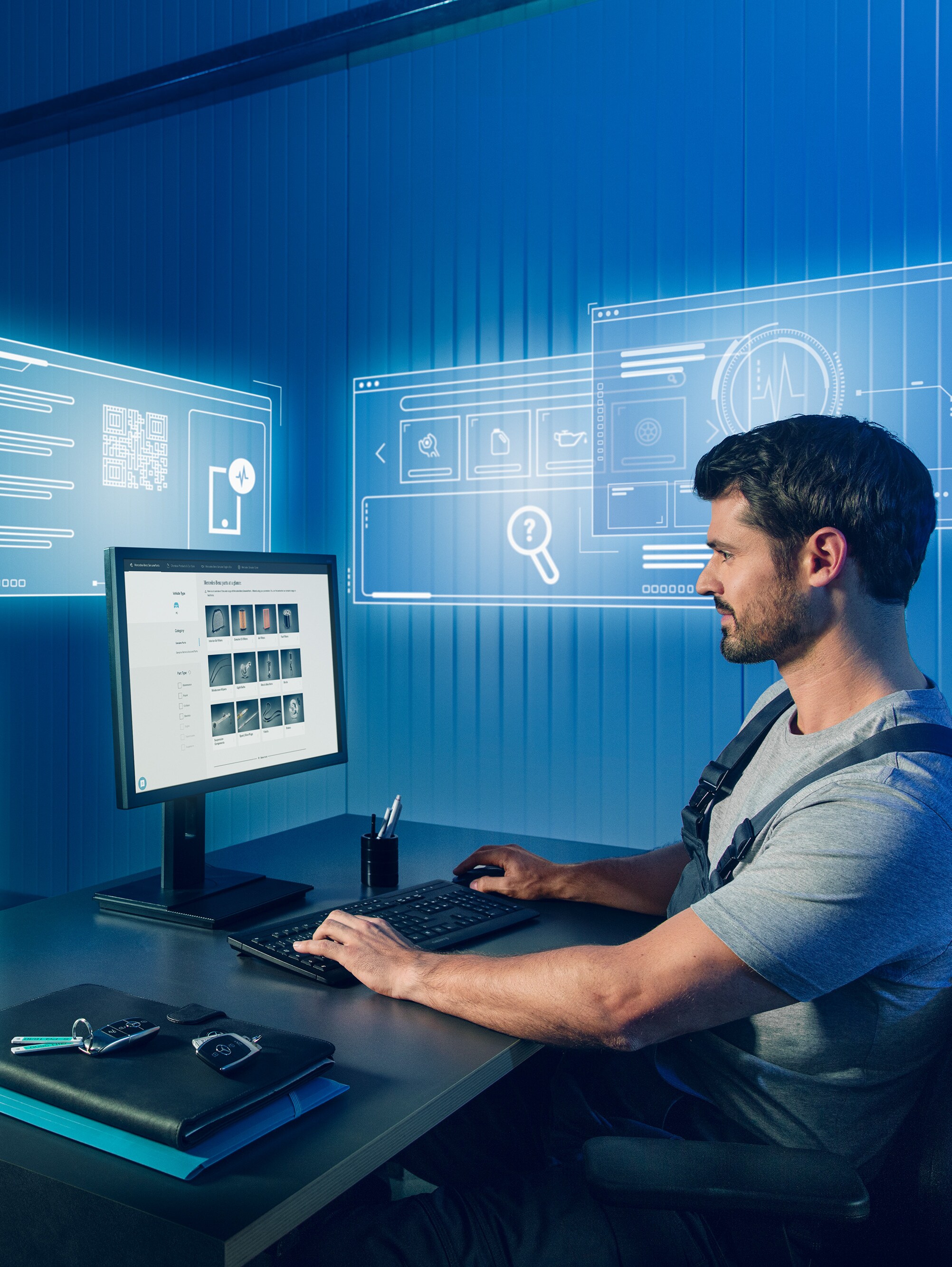 Le mécanicien recherche les pièces d'origine Mercedes-Benz appropriées dans le catalogue de pièces détachées Mercedes sur l'ordinateur.
