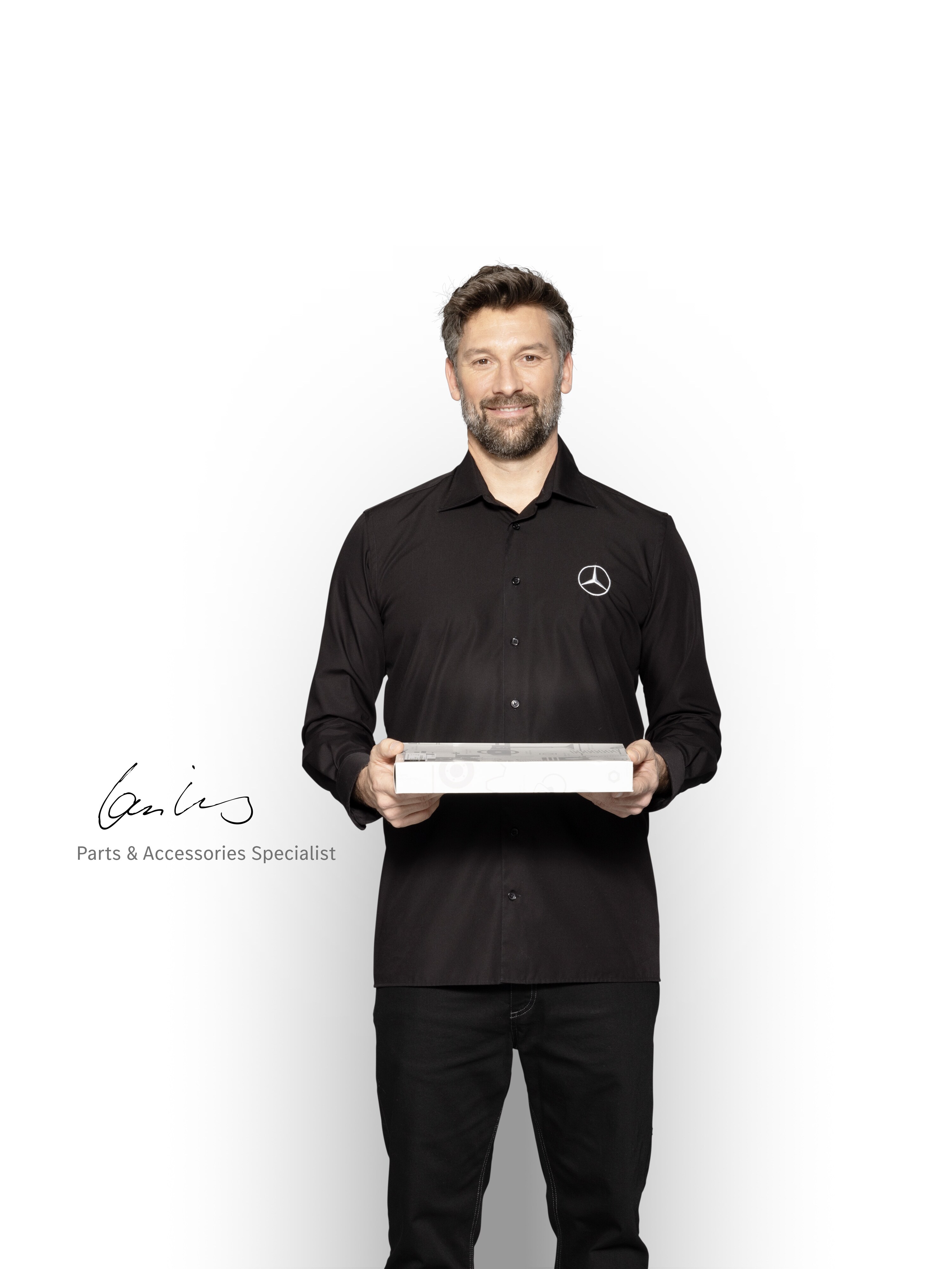 Spécialiste des pièces détachées disposant d'une tablette, prêt à vous informer sur les normes de qualité Mercedes-Benz.