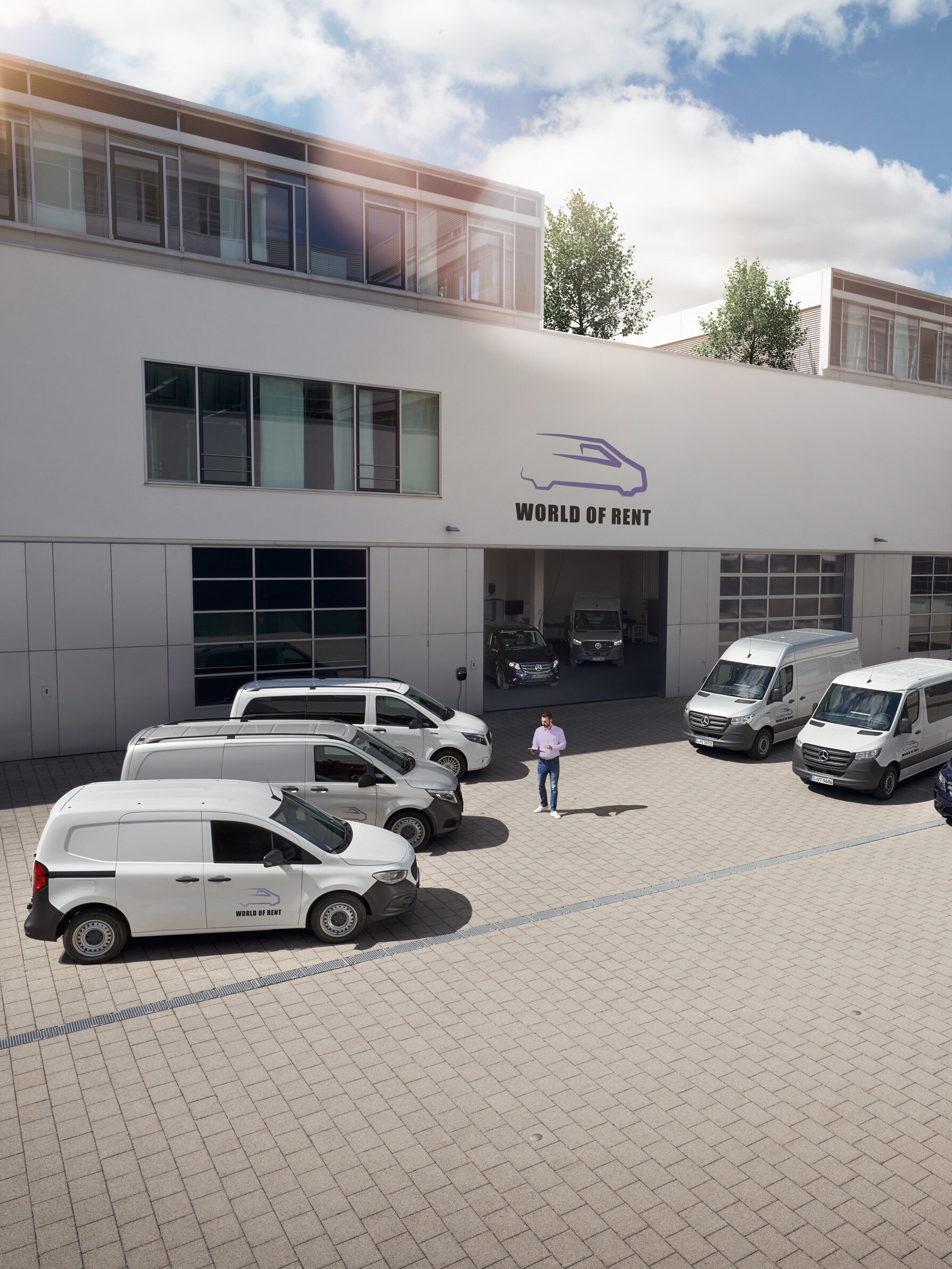 Une flotte d’utilitaires légers Mercedes-Benz devant un bâtiment d'entreprise.