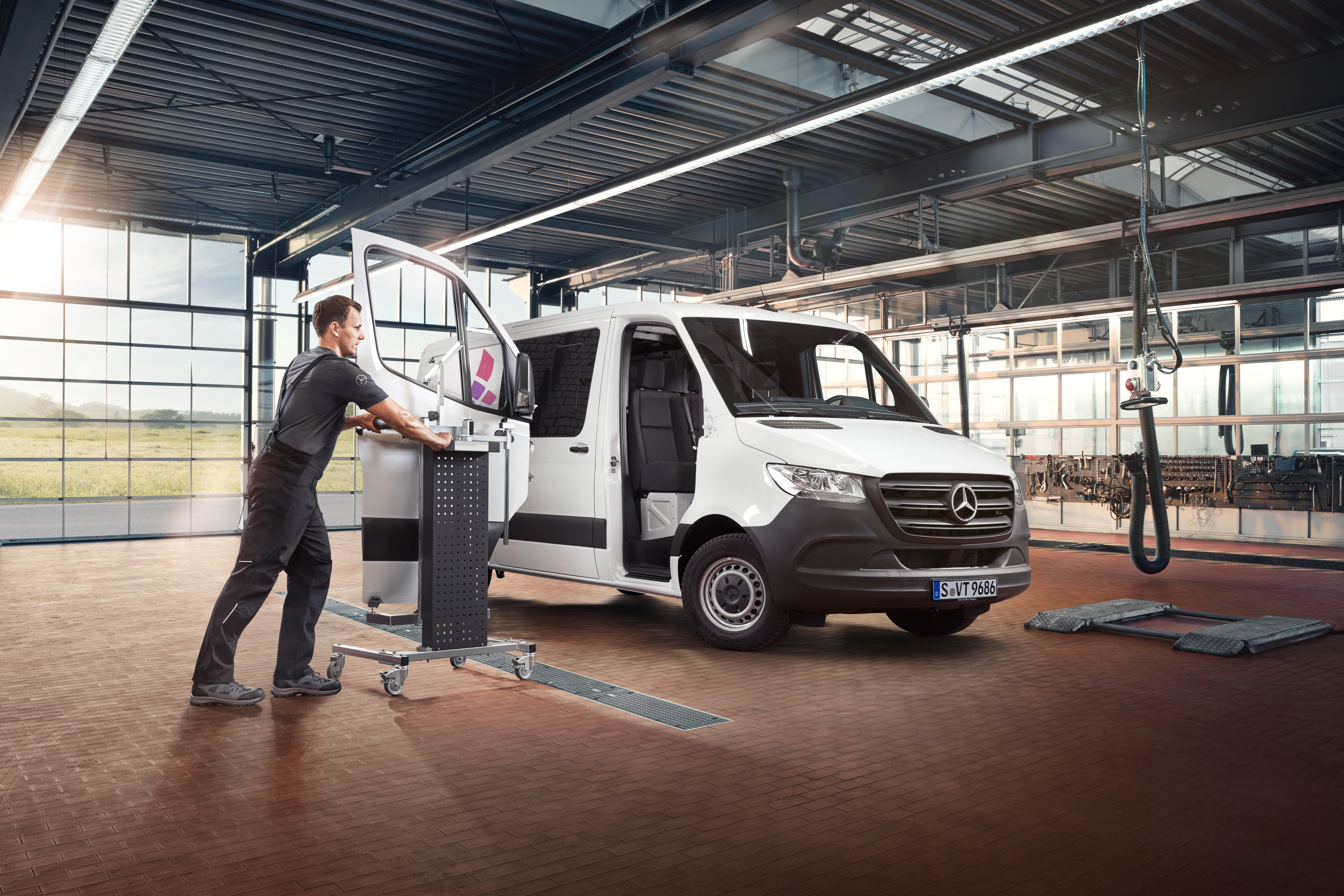 Mercedes-Benz | Aperçu des services | Réparation Un technicien entretient la porte passager d’un utilitaire léger Mercedes-Benz Sprinter blanc.