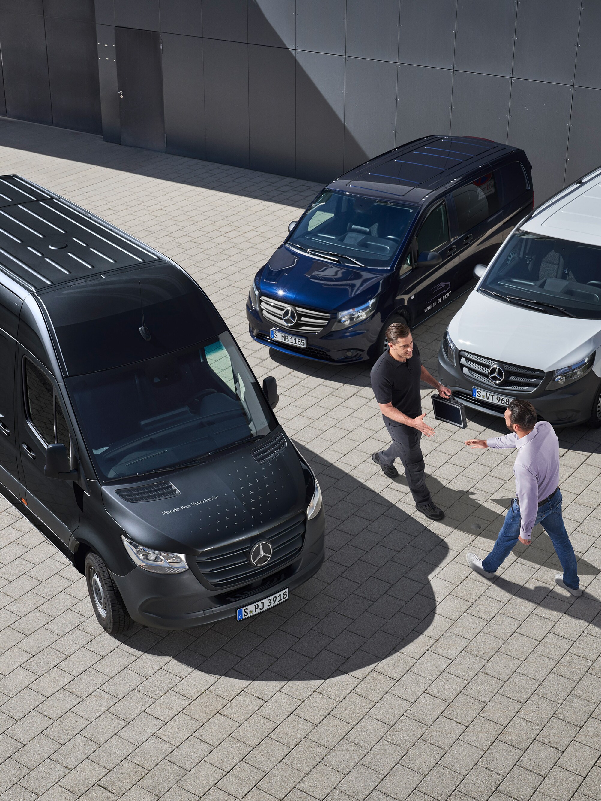 Deux hommes se saluent au milieu d’utilitaires légers Mercedes-Benz.