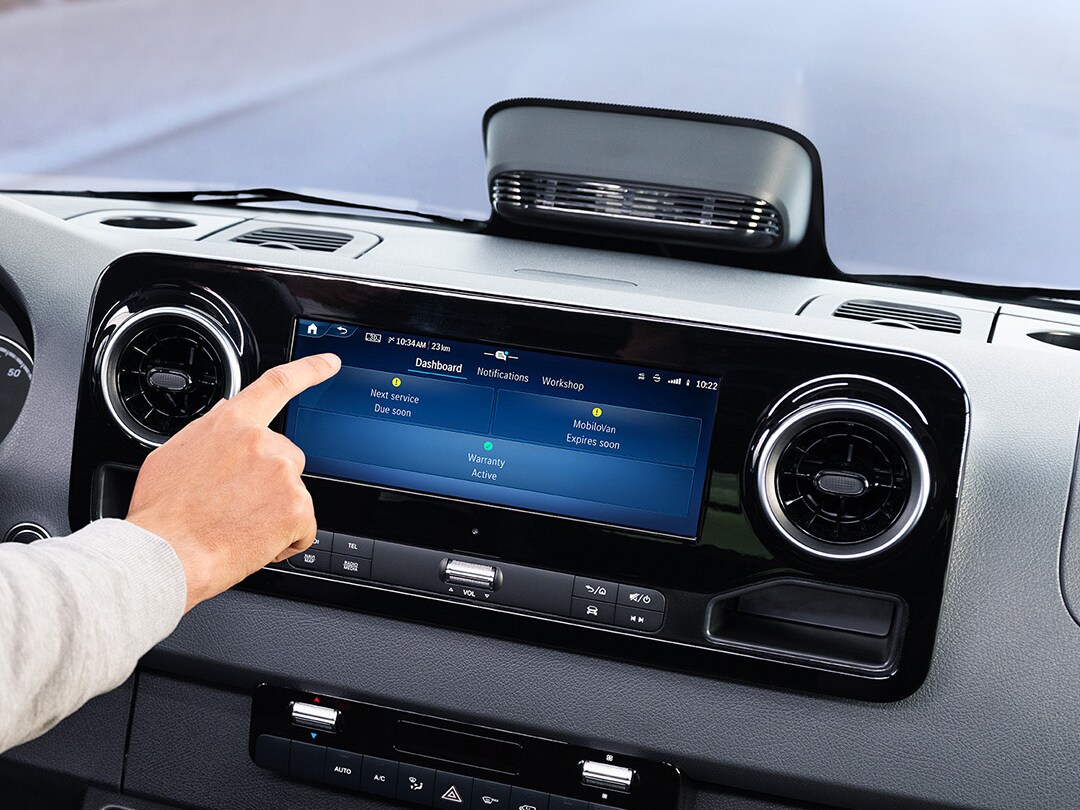 Conducteur utilisant l'application de service sur l'écran du véhicule pour vérifier les données du véhicule et les options de service.
