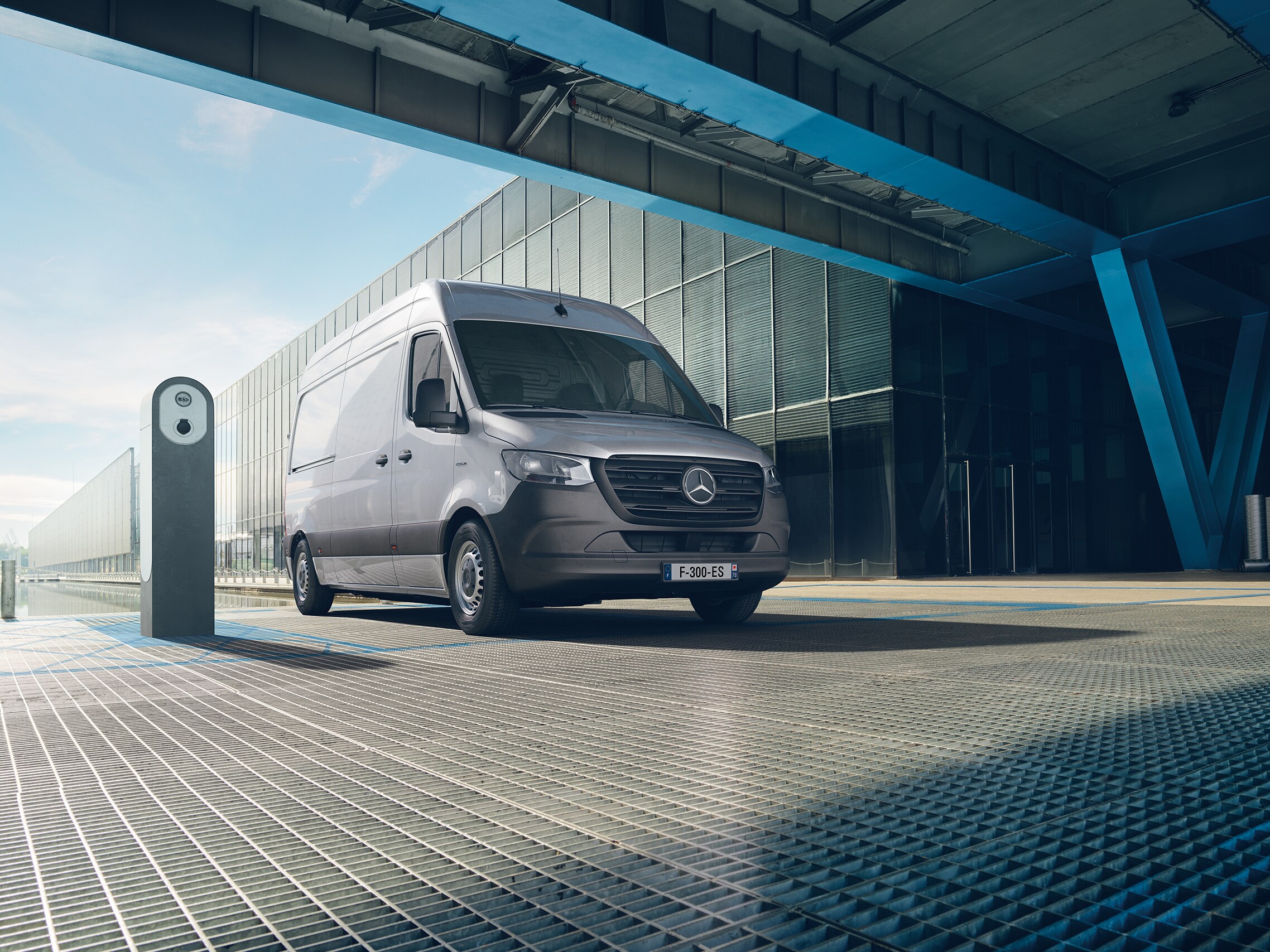 Le fourgon eSprinter, un utilitaire léger électrique de Mercedes-Benz, roule dans un paysage urbain.